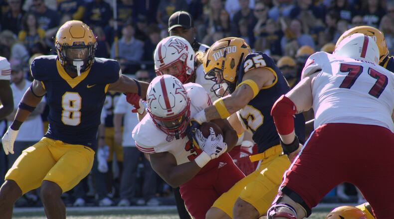 Keyon Mozee holds onto the ball while getting tackled against Toledo on Oct. 5. Kasey Turman/CONTRIBUTED