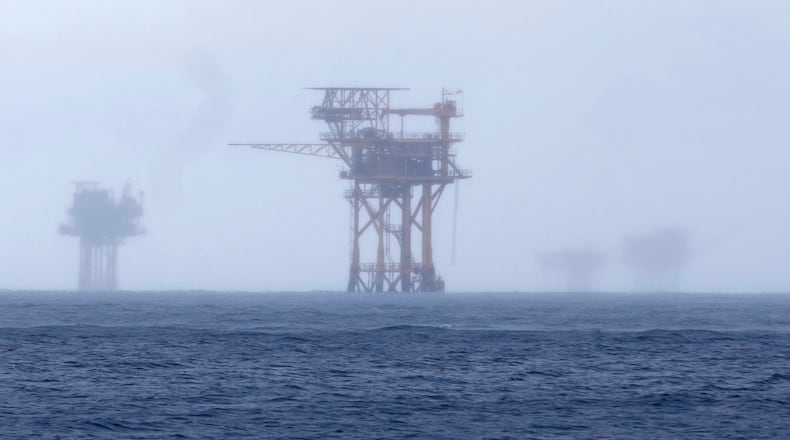 FILE - Oil platforms are visible through the haze near the Flower Garden Banks National Marine Sanctuary in the Gulf of Mexico, off the coast of Galveston, Texas, Saturday, Sept. 16, 2023. (AP Photo/LM Otero, File)