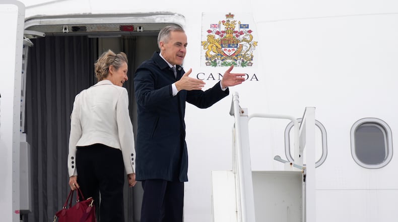 Canadian Prime Minister Mark Carney and his wife Diana Fox Carney board a government plane in Ottawa on Thursday, Feb. 26, 2026. (Adrian Wyld/The Canadian Press via AP)