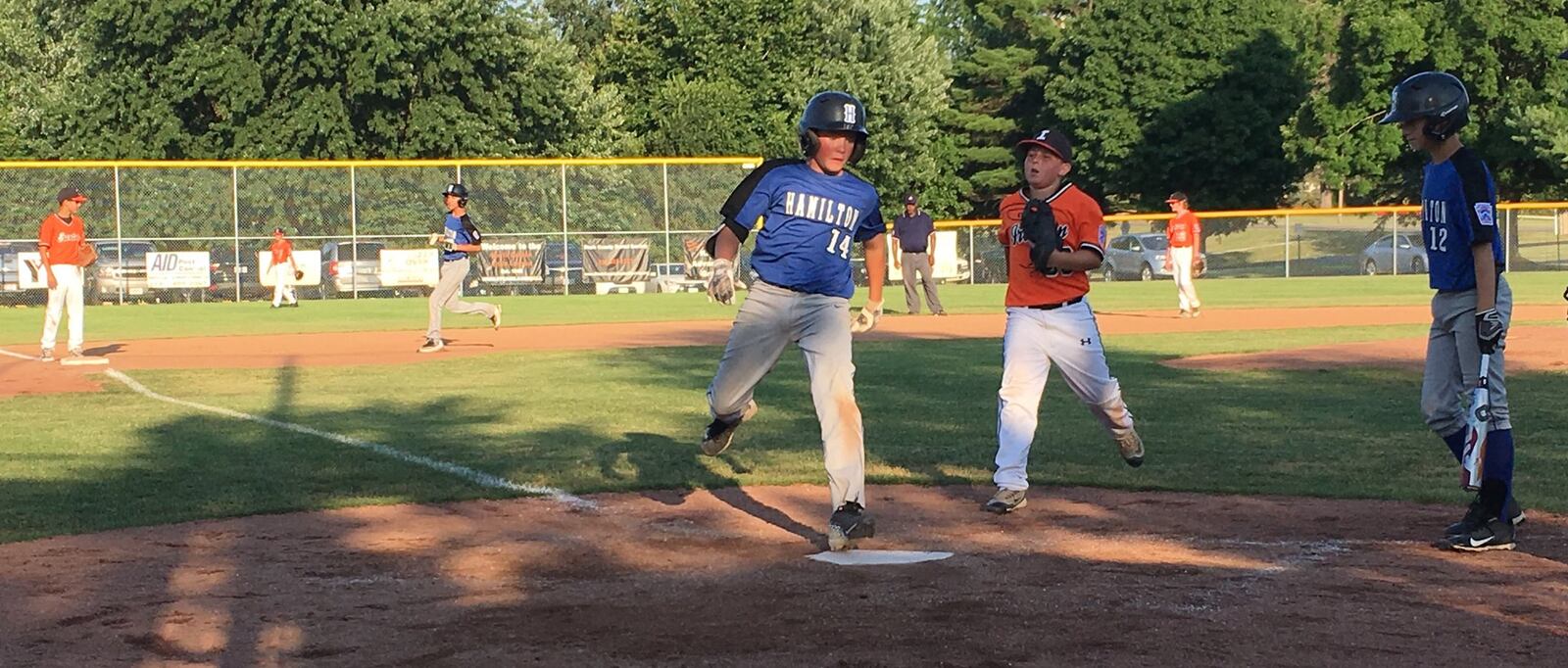 Hamilton West Side’s Nick Brosius scores on a wild pitch as teammate Eddie Tanner (12) and Ironton pitcher Hunter Freeman watch Wednesday night during an Ohio Little League Tournament game at the Hoover Community Recreation Complex in North Canton. West Side won 13-3 in five innings. RICK CASSANO/STAFF