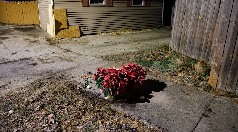 Flowers and candles were left near the intersection of River Road and Hooven Avenue on Sunday, Dec. 21, 2025. The area was the site of a crash that killed three people earlier in the day. NICK GRAHAM / STAFF