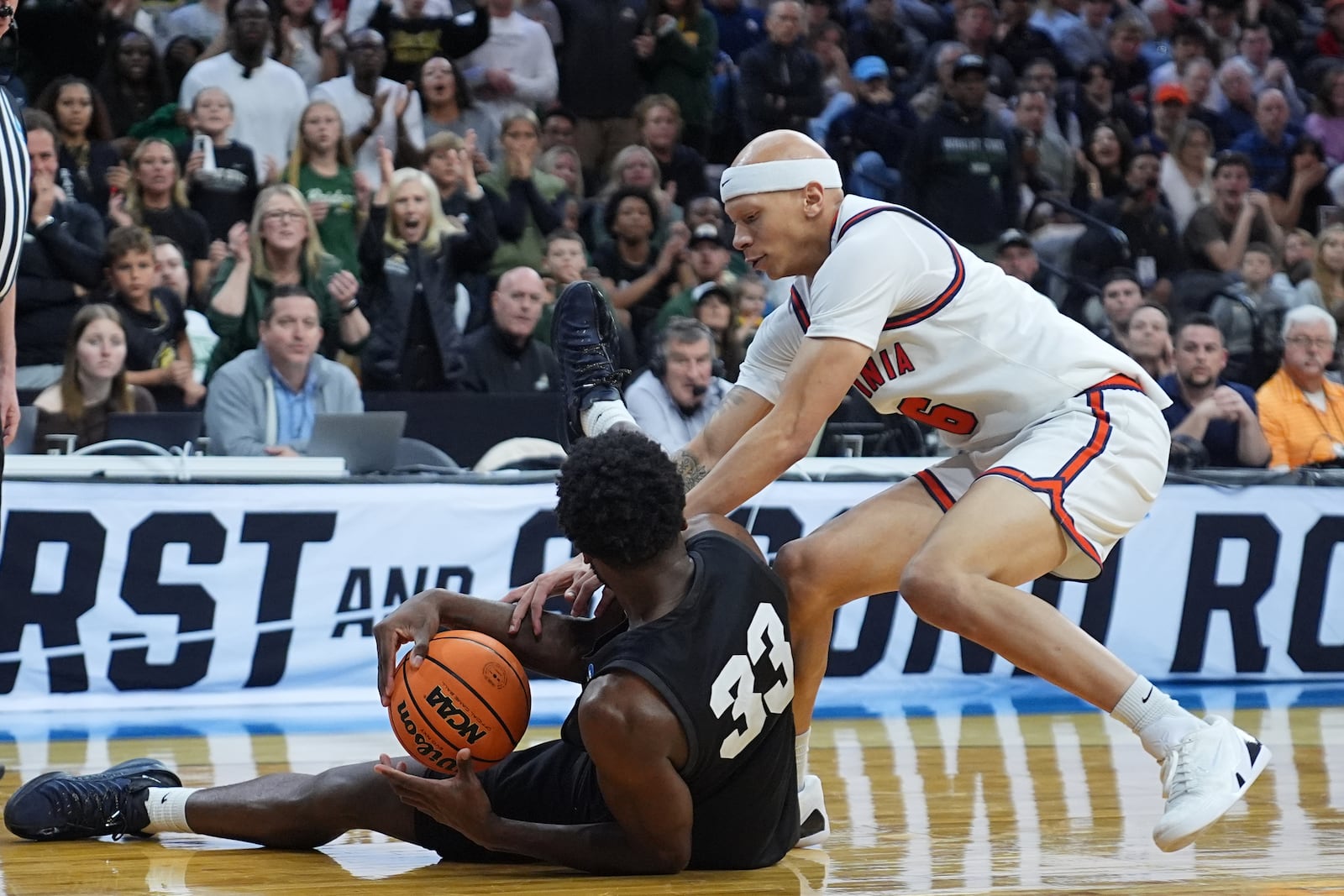 Virginia's Jacari White, right, and Wright State's Michael Imariagbe battle for the ball during the first second in the first round of the NCAA college basketball tournament, Friday, March 20, 2026, in Philadelphia. (AP Photo/Matt Rourke)
