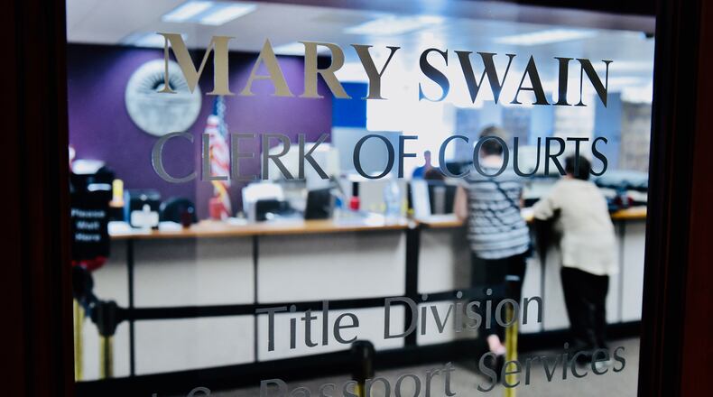 Customers stand inside the Butler County Clerk of Courts title office in the Government Services Center NICK GRAHAM/STAFF