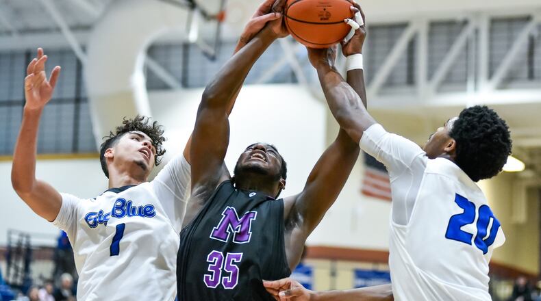 Middletown’s Jayden Burks, middle, battles for a rebound with Hamilton’s Trey Robinson, left, and Jayden Marshall during their game Friday, Jan. 3, 2020 at Hamilton High School. Hamilton Big Blue basketball defeated the Middletown Middies 41-38. NICK GRAHAM / STAFF