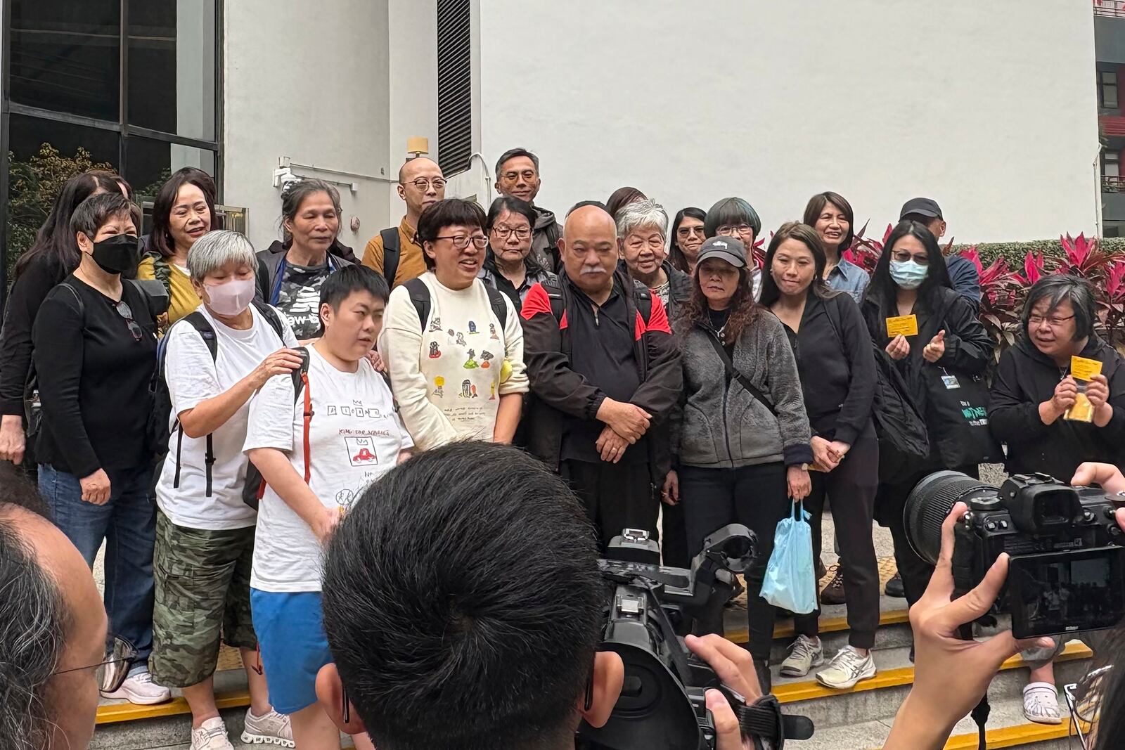 Hong Kong social worker Jackie Chen, second left in bottom row, pose for a photo with her supporters outside the District Court building in Wan Chai, Hong Kong ahead of her verdict hearing Tuesday, March 11, 2025. (AP Photo/Kanis Leung)