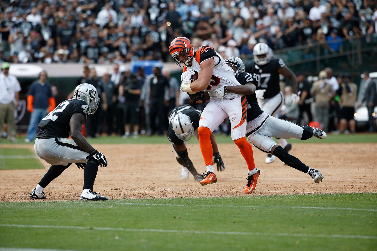 Cincinnati Bengals tight end Tyler Eifert (85) runs as Oakland Raiders cornerback Charles Woodson (24) tries to tackle him during the first half of an NFL football game in Oakland, Calif., Sunday, Sept. 13, 2015. (AP Photo/Tony Avelar)