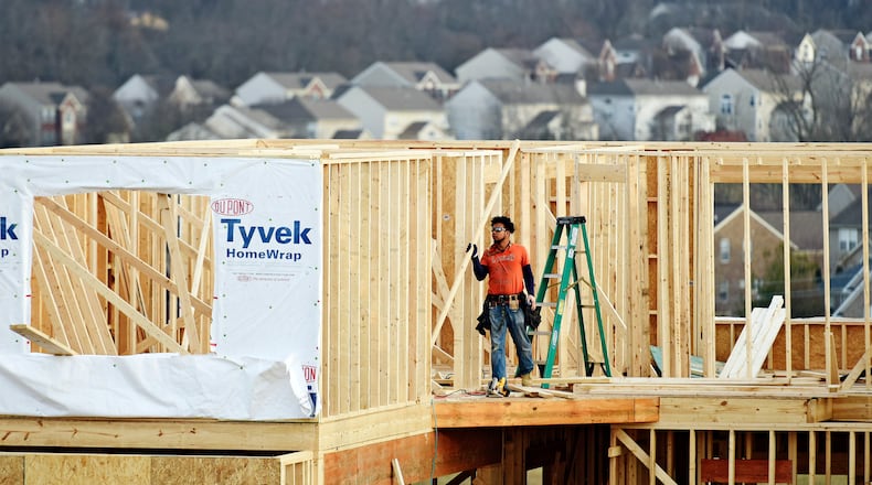 A crew works on construction of a new home in Liberty Twp. NICK GRAHAM/STAFF