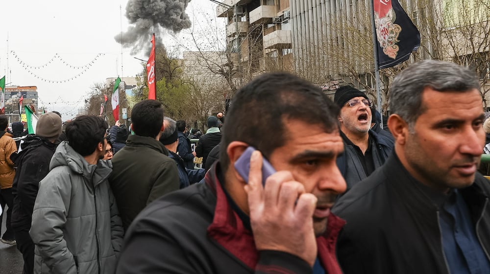 Smoke from an explosion rises behind demonstrators attending the annual anti-Israeli Quds Day, or Jerusalem Day, rally in support of Palestinians in Tehran, Iran, Friday, March 13, 2026. (Mohammad Mahdi Dehghani/Fars News Agency via AP)