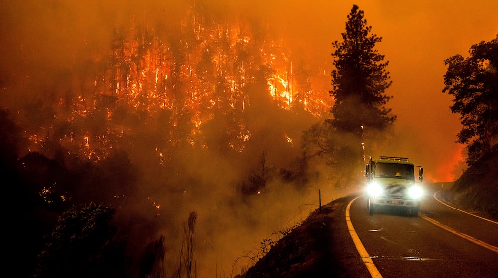 FILE - A firetruck drives along California Highway 96 as the McKinney Fire burns in Klamath National Forest, Calif., on July 30, 2022. (AP Photo/Noah Berger, File)
