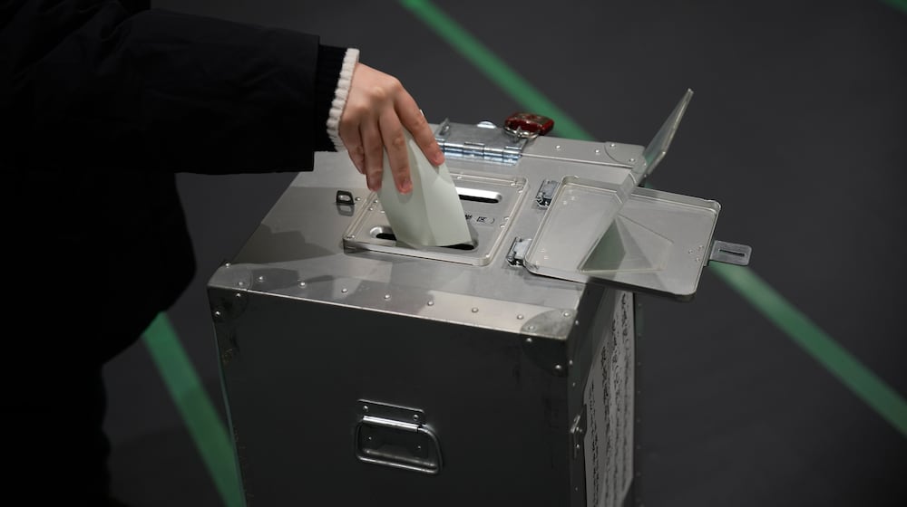A voter fills in a ballot in the upper house election at a polling station Sunday, Feb. 8, 2026, in Tokyo. (AP Photo/Louise Delmotte)