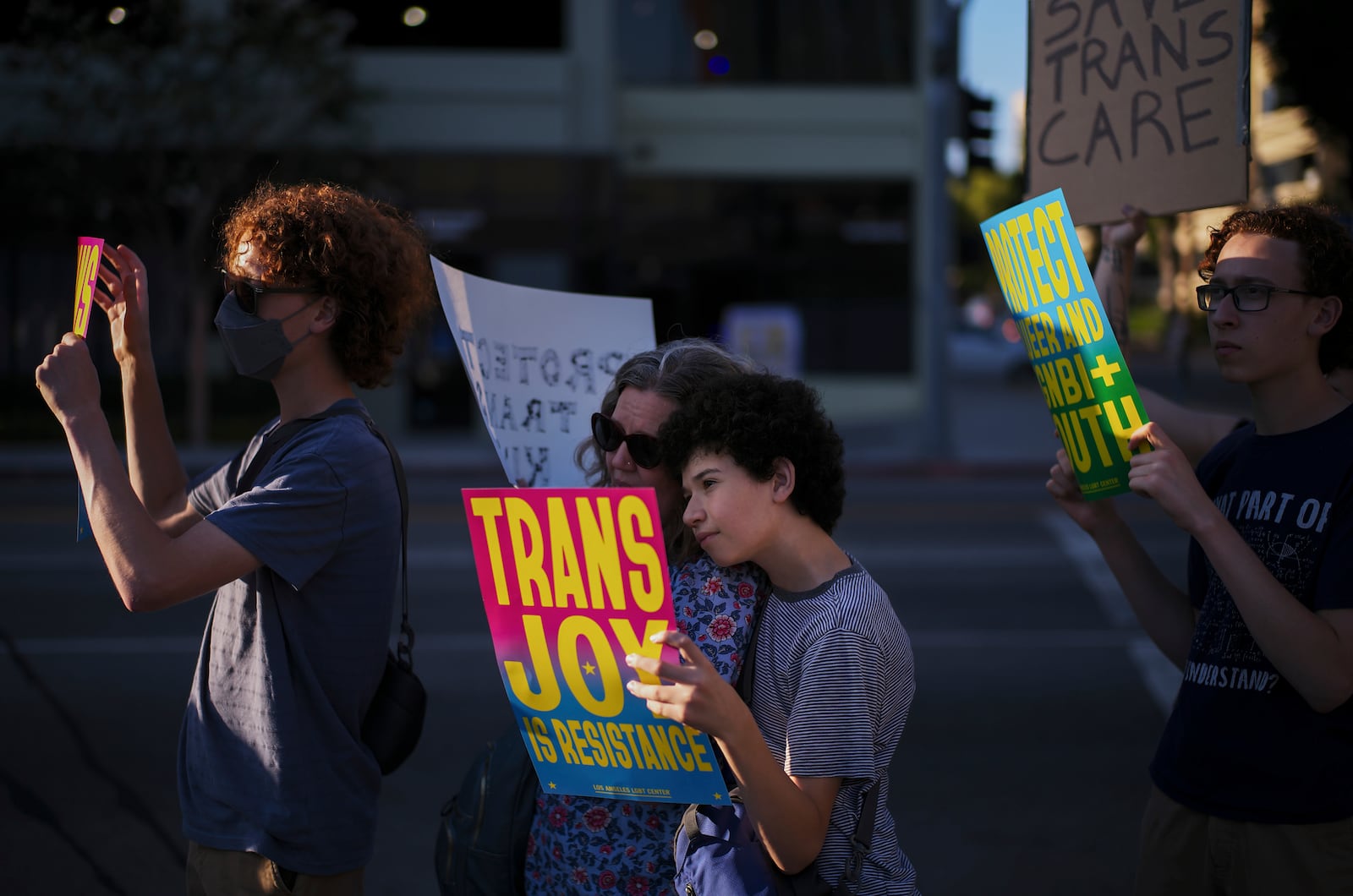 Lindsey Nelson, center left, and her son, Max Deiner, take part in a protest against the closure of the trans youth clinic at Children's Hospital Los Angeles, Thursday, July 3, 2025, in Los Angeles. (AP Photo/Jae C. Hong)