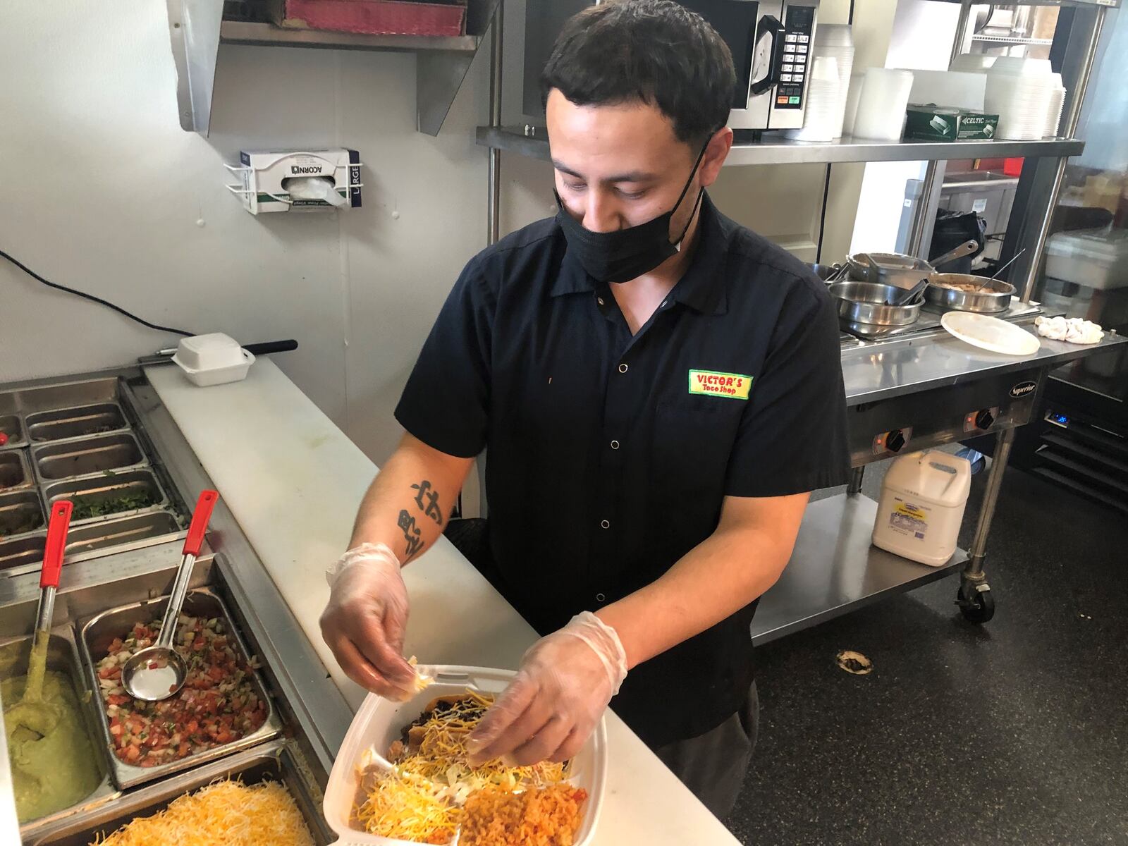 General manager Luis Gaytan, 31, prepares a two taco combo Monday afternoon inside Victor's Taco Shop in Monroe. The Mexican restaurant recently opened it first Butler County location in the IGA shopping center on East Avenue. RICK McCRABB/STAFF