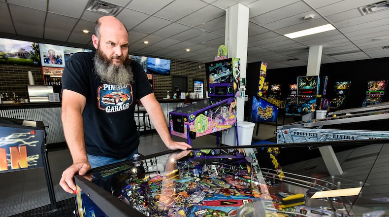 Pinball Garage owner Brad Baker plays the brand new Teenage Mutant Ninja Turtles pinball game Thursday, June 25, 2020. Pinball Garage is now open in downtown Hamilton and offers a large selection of pinball machines to play along with a bar with rotating beer selection. NICK GRAHAM / STAFF