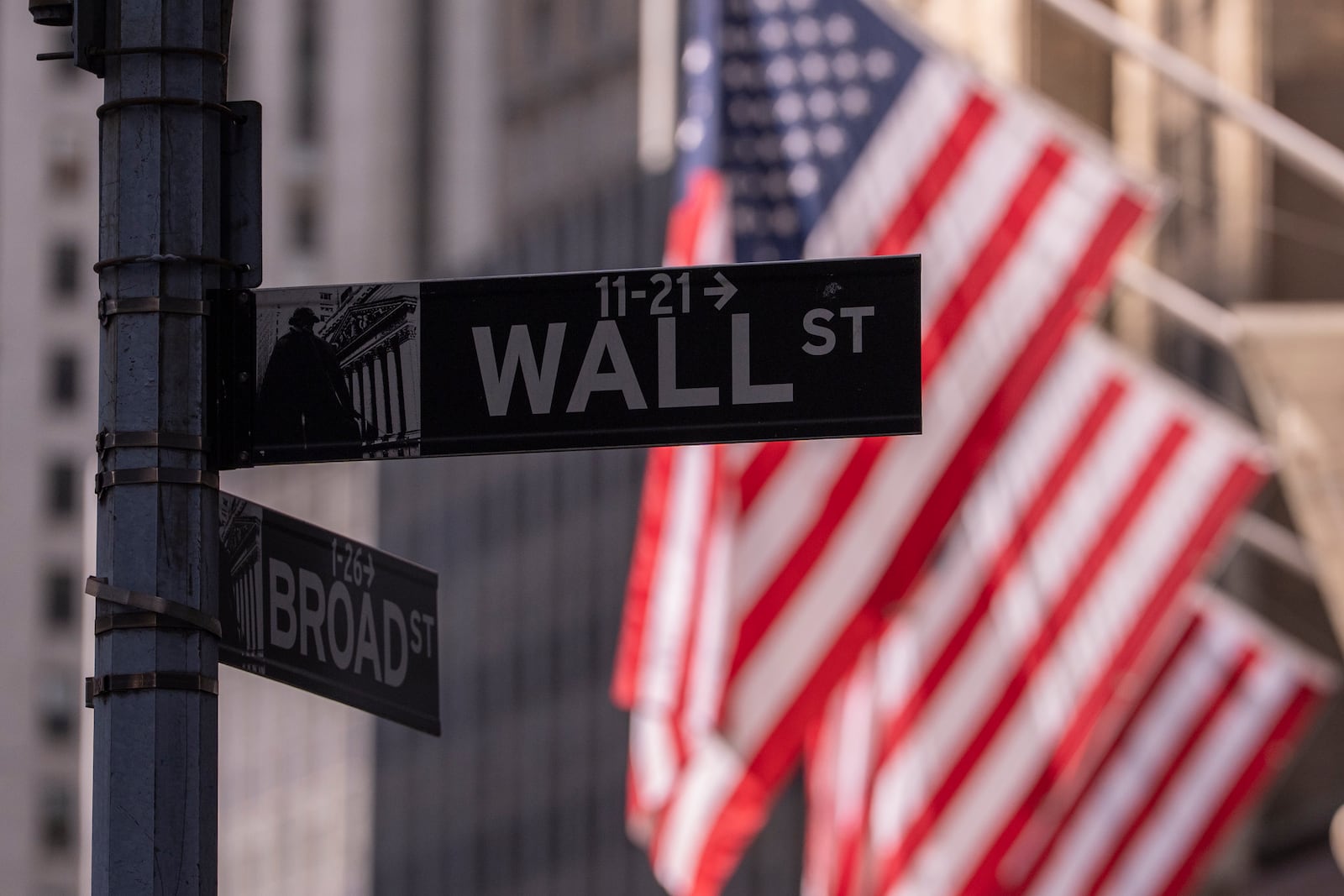 Wall Street sign hangs next to the New York Stock Exchange on Monday, June 30, 2025, in New York. (AP Photo/Yuki Iwamura)