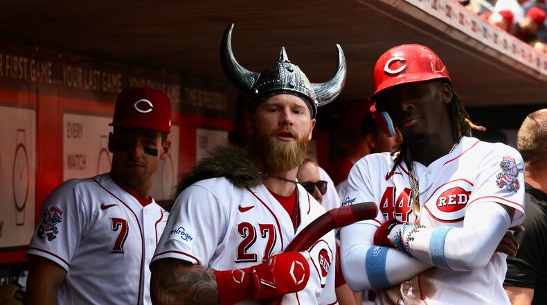 Jake Fraley, center, and Elly De La Cruz, right, pose for a photo as Spencer Steer, left, watches after Fraley's tie-breaking two-run home run in the eighth inning Wednesday against the Colorado Rockies at Great American Ball Park in Cincinnati. David Jablonski/Staff