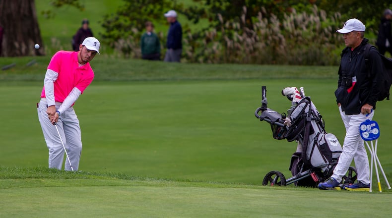 Lakota East senior Joe Wilson IV chips onto the green as coach Jeff Combs looks on Saturday during final round of the Division I boys state golf tournament. Jeff Gilbert/CONTRIBUTED