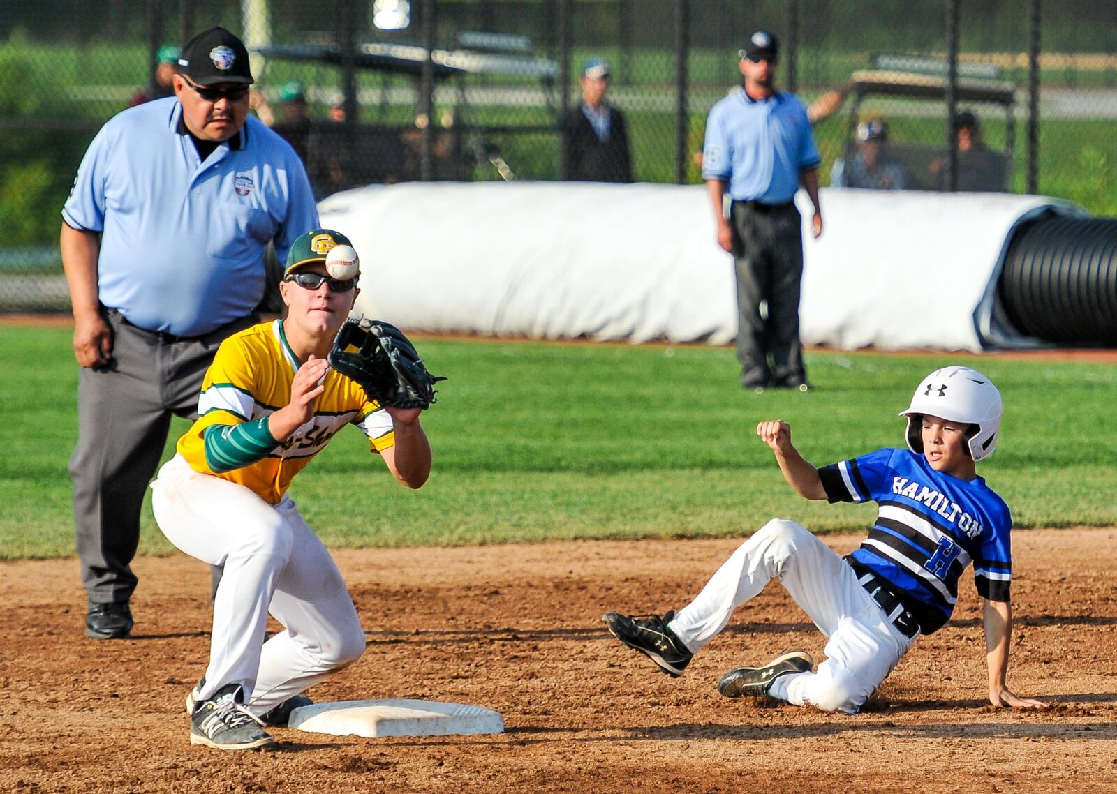 Hamilton West Side’s Clint Moak slides safely under a tag from Grosse Pointe Woods-Shores (Mich.) second baseman Joseph Wisniewski during Hamilton’s 11-3 loss Friday at the Little League Great Lakes Regional at Grand Park Sports Campus in Westfield, Ind. NICK GRAHAM/STAFF