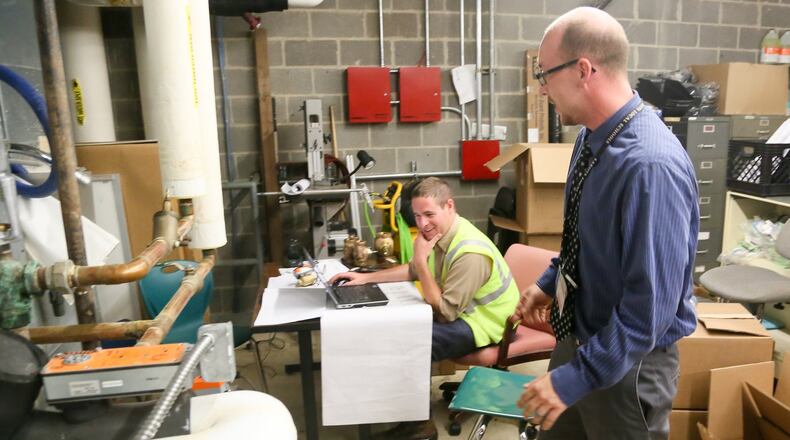 Neil Persley, Lakota Local Schools Facilities & Operations Manger and Jon Rohrkasse of Trane Heating and Cooling work on a pumping system in a mechanical room at Lakota East High School, Thursday, June 22, 2017. GREG LYNCH / STAFF