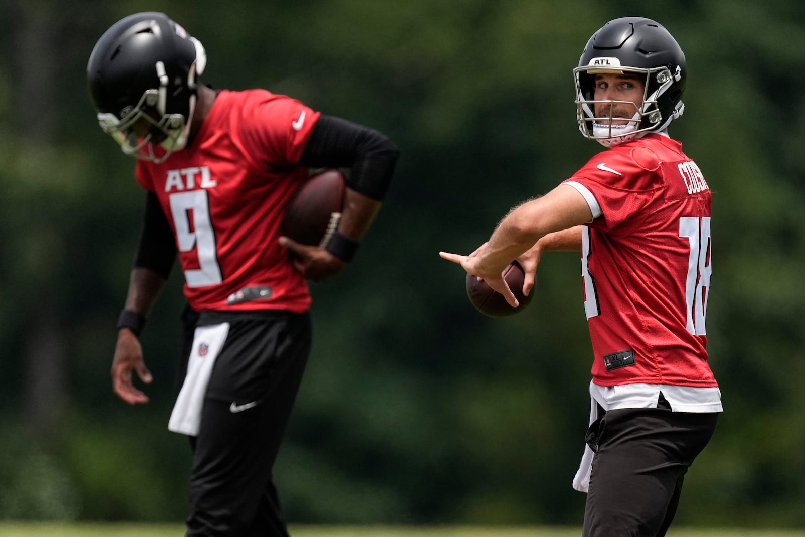 Atlanta Falcons quarterback Kirk Cousins, right and quarterback Michael Penix Jr., work out during practice at NFL football minicamp, Tuesday, June 10, 2025, in Flowery Branch, Ga. (AP Photo/Mike Stewart)