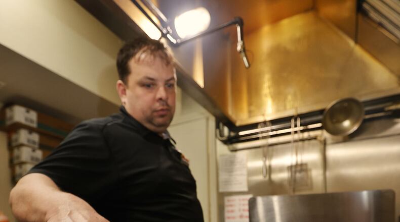 Brent Dalton cooks an order of chicken wings on the grill at Brent's Smokin' Butts & Grill on Central Avenue in Middletown. Dalton plans to move his downtown business to North University Boulevard later this year. NICK GRAHAM/STAFF