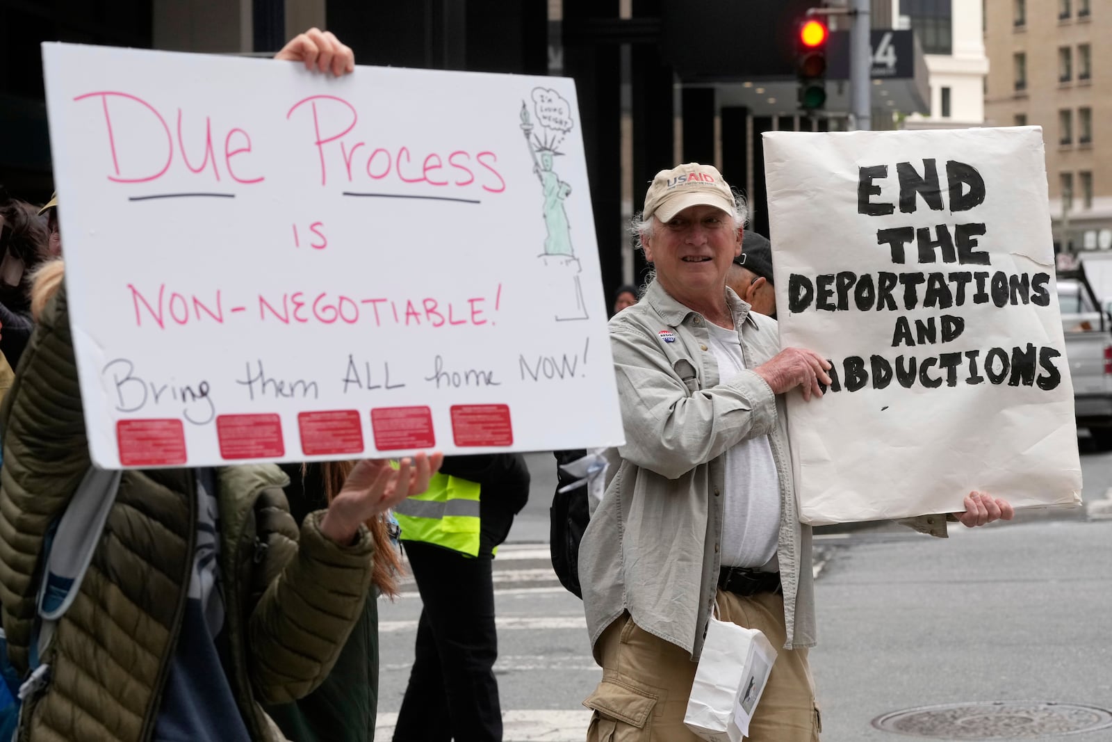 People hold up signs protesting ICE arrests during a news conference and rally by immigrant justice organizations and advocates in San Francisco, Wednesday, May 28, 2025. (AP Photo/Jeff Chiu)