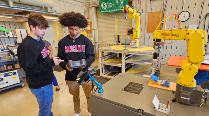 Trent Saylor and LaShawn Crockett tour the robotics lab at Sinclair Community College. Saylor and Crockett are apprentices earning an Associate's Degree in Automation & Control Technology with Robotics from Sinclair, while simultaneously gaining hands-on manufacturing experience at United Grinding North America. SINCLAIR/CONTRIBUTED