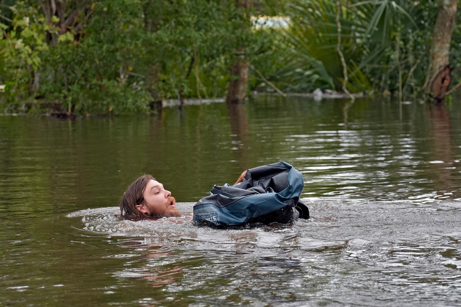 FILE - Connor Hughes of Lithia, Fla., moves in deep floodwaters from Hurricane Milton along the Alafia River, Oct. 11, 2024, in Lithia, Fla. (AP Photo/Chris O'Meara, File)