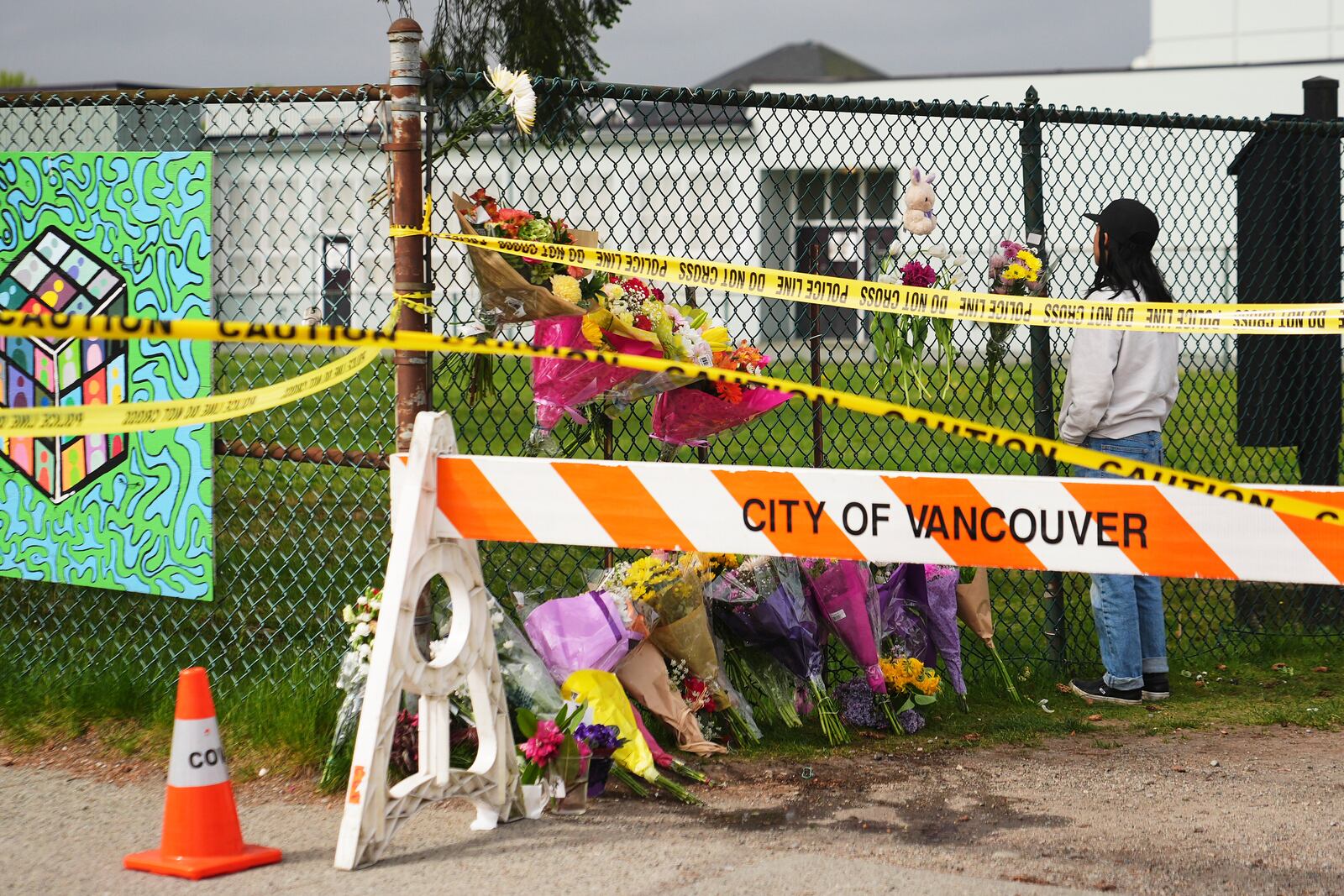 Sarah Edmilao, a member of the Filipino community who says friends had attended earlier in the day, views flowers at a growing memorial near a site the day after a driver killed multiple people during a Filipino festival Sunday, April 27, 2025, in Vancouver, British Columbia. (AP Photo/Lindsey Wasson)