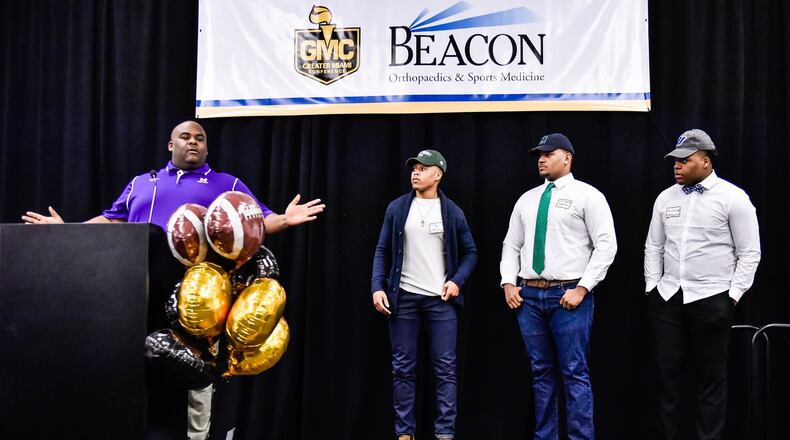 Middletown assistant coach Ayron Thompson introduces his players during the Greater Miami Conference Signing Day event Wednesday at the Sharonville Convention Center. Pictured left to right are Diondre Cooper (Mercyhurst), Ayron Thompson Jr. (Mercyhurst) and Keion Williams (Urbana). NICK GRAHAM/STAFF