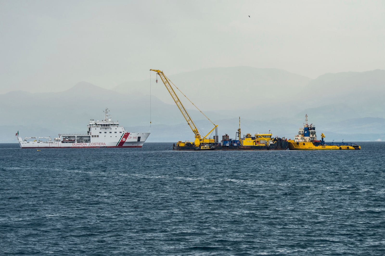 Italian Coast Guard's Luigi Dattilo patrol boat, left, assists the multi-purpose floating work barge Hebo Lift 2 monitoring the stretch of sea off Porticello, near Palermo, Sicily, Italy, Sunday, May 4, 2025, where the British superyacht Bayesian sunk on August 19, 2024 as the operations for its recovery start. (AP Photo/Salvatore Cavalli)