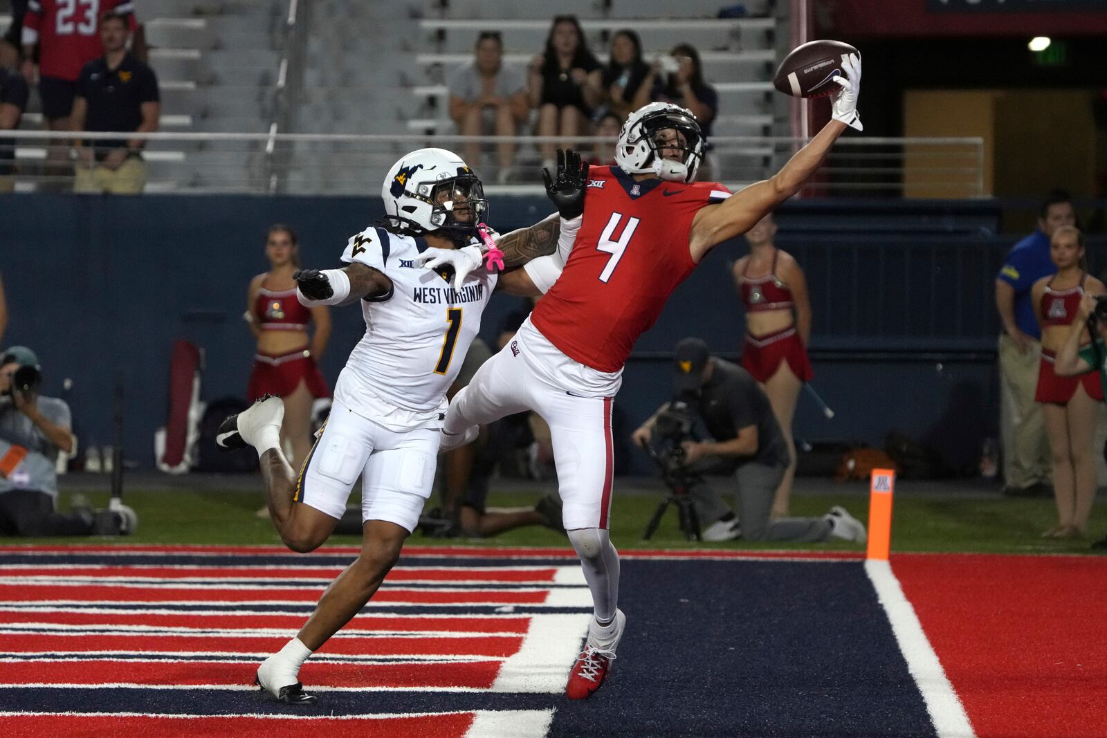 Arizona wide receiver Tetairoa McMillan (4) tries to make the catch over West Virginia cornerback Garnett Hollis Jr. in the second half during an NCAA college football game, Saturday, Oct. 26, 2024, in Tucson, Ariz. (AP Photo/Rick Scuteri)