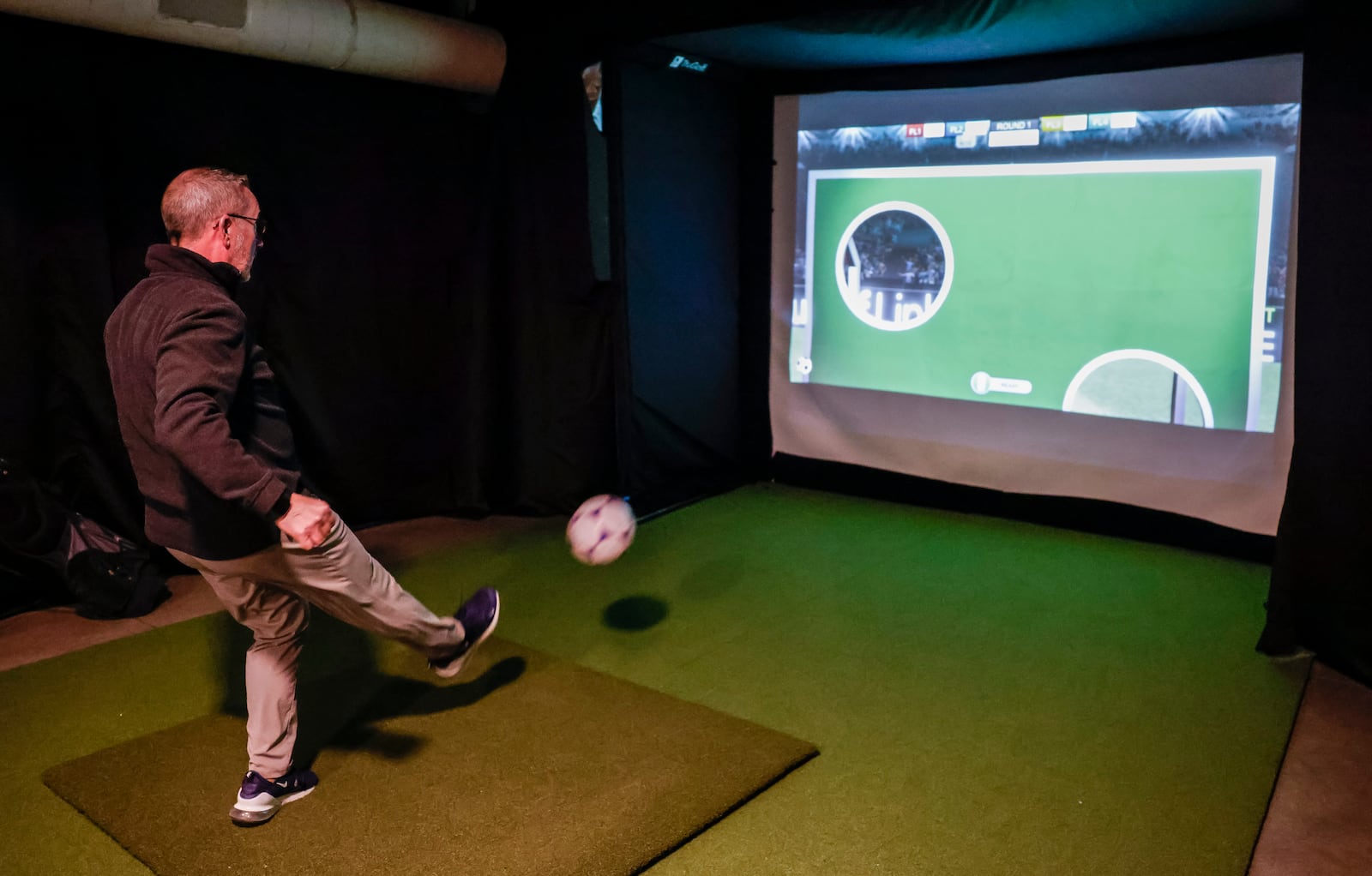 Jim Burns shows how the simulator works at Inside 18 golf and sports simulator Thursday, Jan. 15, 2026 at Spooky Nook Sports Champion Mill in Hamilton.  The new indoor sports simulator facility is mostly used for golf, but it also features baseball, soccer, football and other sports. NICK GRAHAM/STAFF