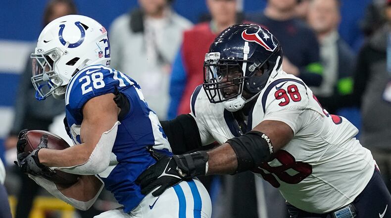 FILE- Houston Texans defensive tackle Sheldon Rankins (98) tackles Indianapolis Colts running back Jonathan Taylor (28) of an NFL football game Saturday, Jan. 6, 2024, in Indianapolis. The Cincinnati Bengals have bolstered their defense by agreeing on contracts with defensive tackle Sheldon Rankins and safety Vonn Bell, two people familiar with the terms told The Associated Press on Thursday, March 14, 2024. (AP Photo/Darron Cummings, File)