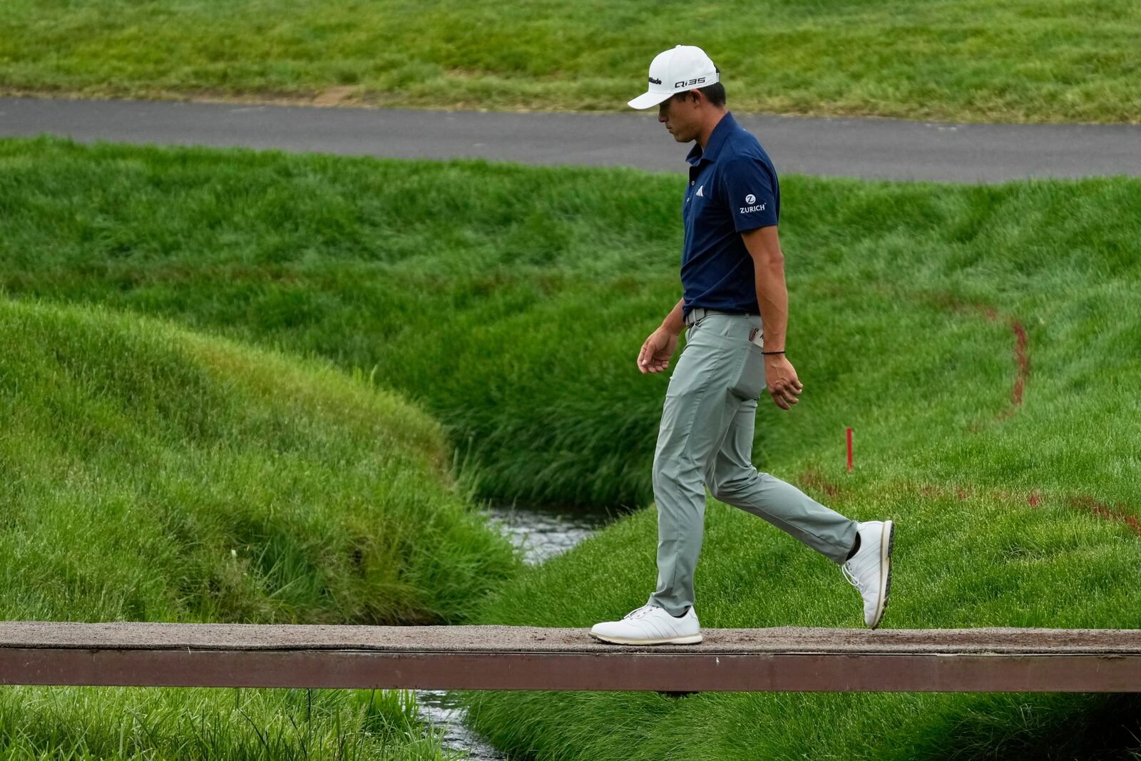 Collin Morikawa walks across a bridge on the second hole during the first round of the Memorial golf tournament, Thursday, May 29, 2025, in Dublin, Ohio. (AP Photo/Sue Ogrocki)