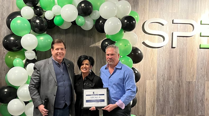 Christine Austin, and her husband Stephen (center and right) celebrate the grand re-opening of their workout studio, SPENGA. They are seen here with Joe Hinson, president and CEO of the West Chester-Liberty Chamber Alliance. CONTRIBUTED