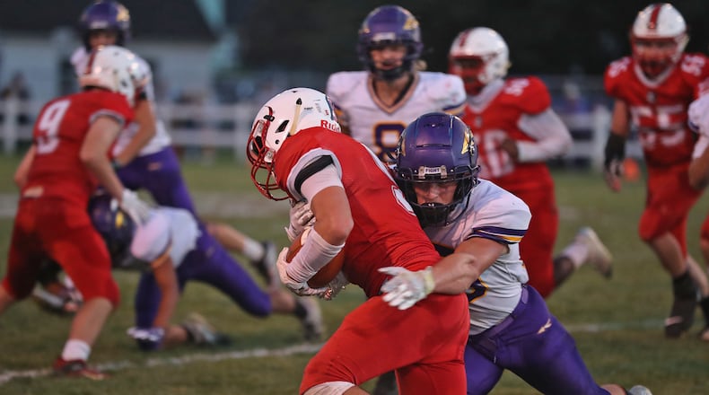 Southeastern's Wade Erickson is tackled by Mechanicsburg's Jake Hurst. BILL LACKEY/STAFF