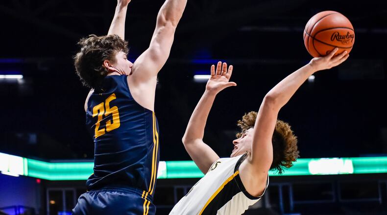 Centerville's Drew Thompson puts up a shot defended by Archbishop Moeller's Michael Currin March 11, 2020 in their Division I Regional boys basketball semifinal at Xavier University's Cintas Center. NICK GRAHAM / STAFF