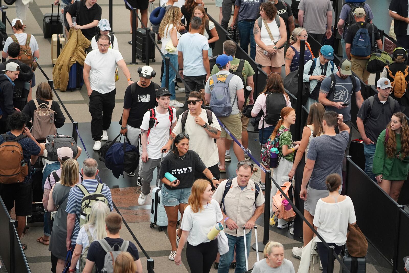 Travelers queue up to pass through the south security checkpoint in Denver International Airport Wednesday, July 2, 2025, in Denver. (AP Photo/David Zalubowski)