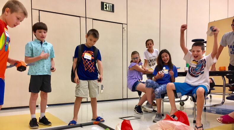 Camp Invention at Highland Elementary is for Hamilton School students in grades 4 to 6 who are invited or gifted students with a history of high academic performance. Students work on a variety of STEM (science, technology, engineering and mathematics) projects during half days at Highland. Here they compete in robot vehicle races through an obstacle course. (Photo by Michael D. Clark/Journal-News)