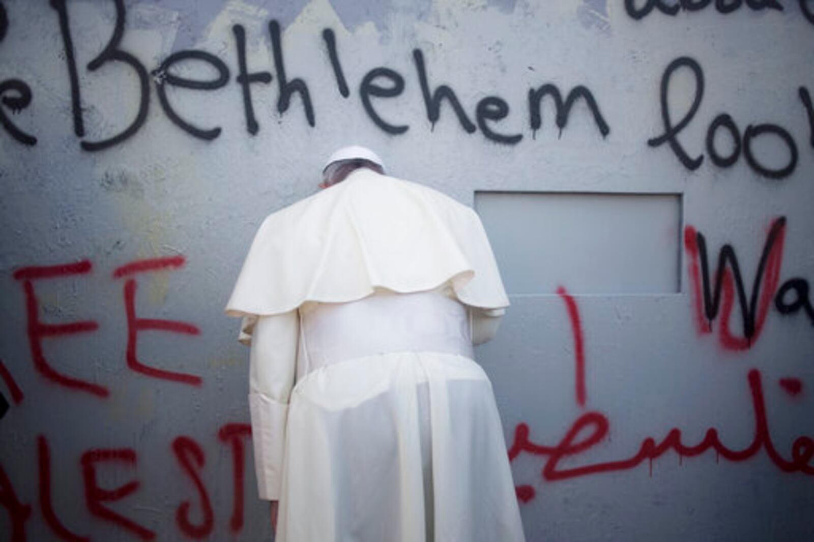 FILE - Pope Francis prays at Israel's separation barrier on his way to a mass in Manger Square next to the Church of the Nativity, in the West Bank city of Bethlehem, Sunday, May 25, 2014. (AP Photo/Ariel Schalit, file)