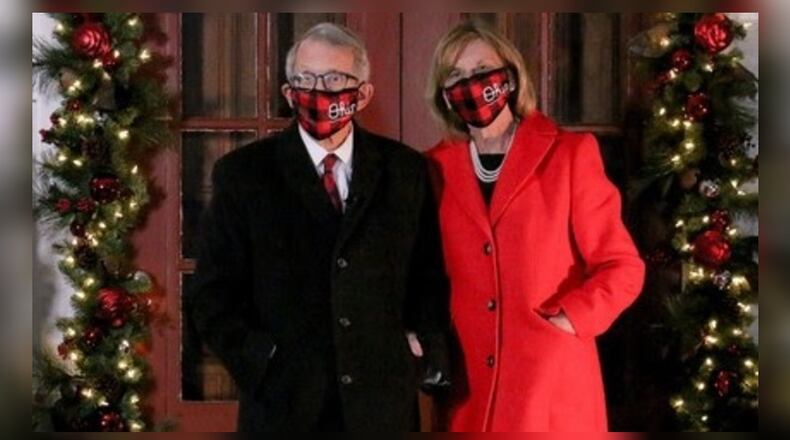 Ohio Gov. Mike DeWine and first lady Fran DeWine don masks as they stand outside their home decorated for the holidays. CONTRIBUTED