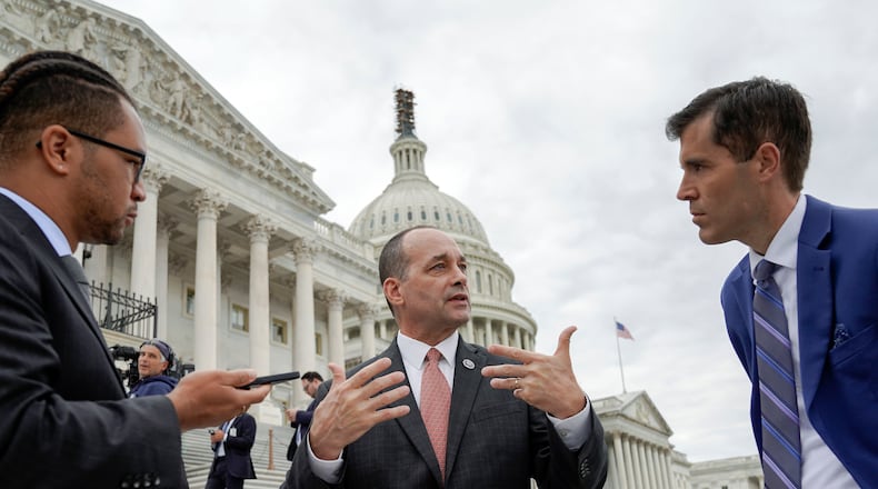 Rep. Greg Landsman, D-Ohio, center, talks with reporters on Capitol Hill, Friday, Oct. 20, 2023, in Washington. (AP Photo/Mariam Zuhaib)