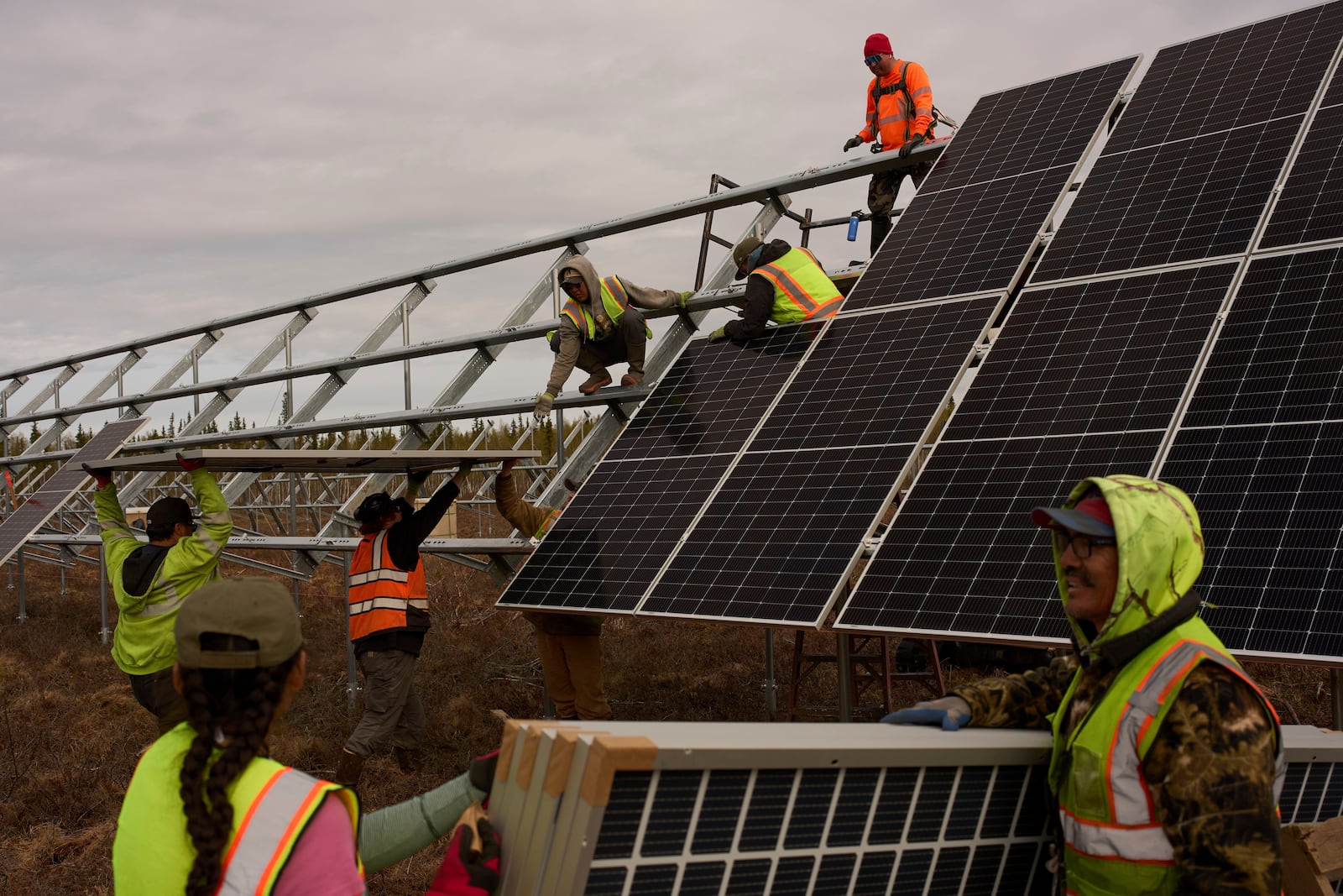 Workers install panels at a solar project Wednesday, May 21, 2025, in Galena, Alaska. (AP Photo/John Locher)