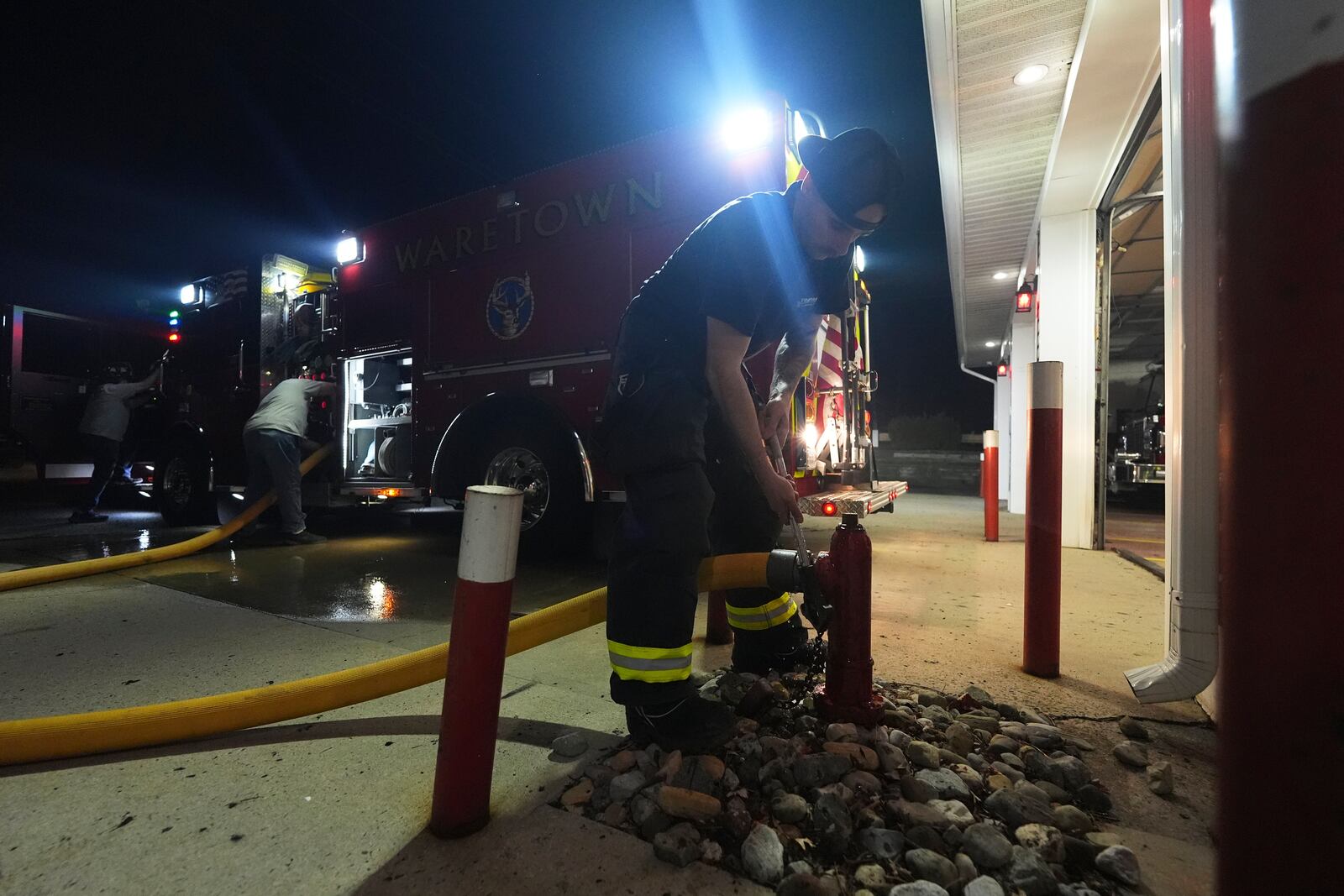 A Waretown volunteer firefighter helps prepare a firetruck to respond to a wildfire on Tuesday, April 22, 2025, in Waretown, N.J. (AP Photo/Chris Szagola)
