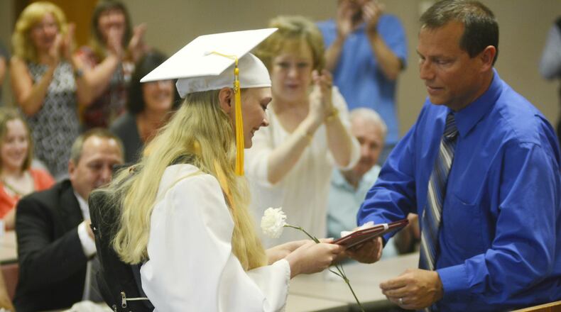 Elizabeth Schulze receives her diploma from Fairfield High School Principal Billy Smith during a special graduation ceremony Friday afternoon at the Fairfield High School’s community room. The graduated senior missed out on graduating with her classmates on May 28 at the Cintas Center due to an illness. She has Ehlers-Danlos syndrome, an inherited genetic disorder that affect a person’s connective tissues.