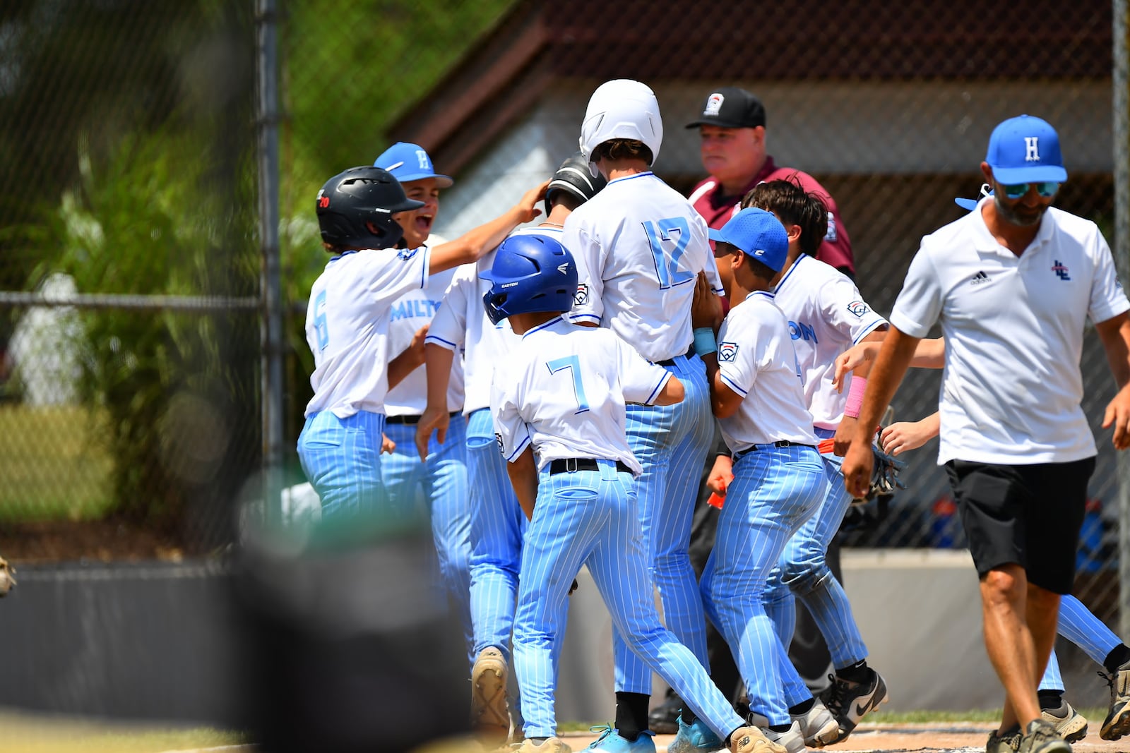 Gavyn Spears is greeted by his West Side Little League teammates after hitting a grand slam during the Ohio Little League state championship game against New Albany on Thursday at the Field of Dreams in Boardman. West Side won 17-5. KYLE HENDRIX / CONTRIBUTED