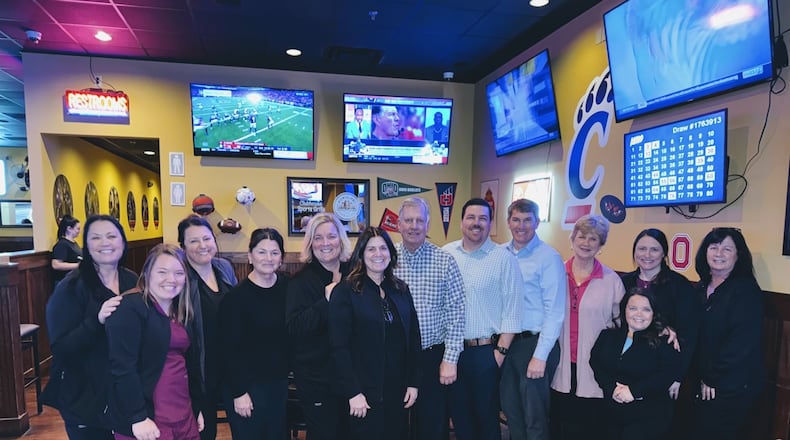 James. R. Zettler, Jr. (center right), celebrates with his staff, including his sons, Steve and Jim, (to his immediate right), in February 2024 his 50th anniversary at Zettler Orthodontics in Hamilton. PROVIDED