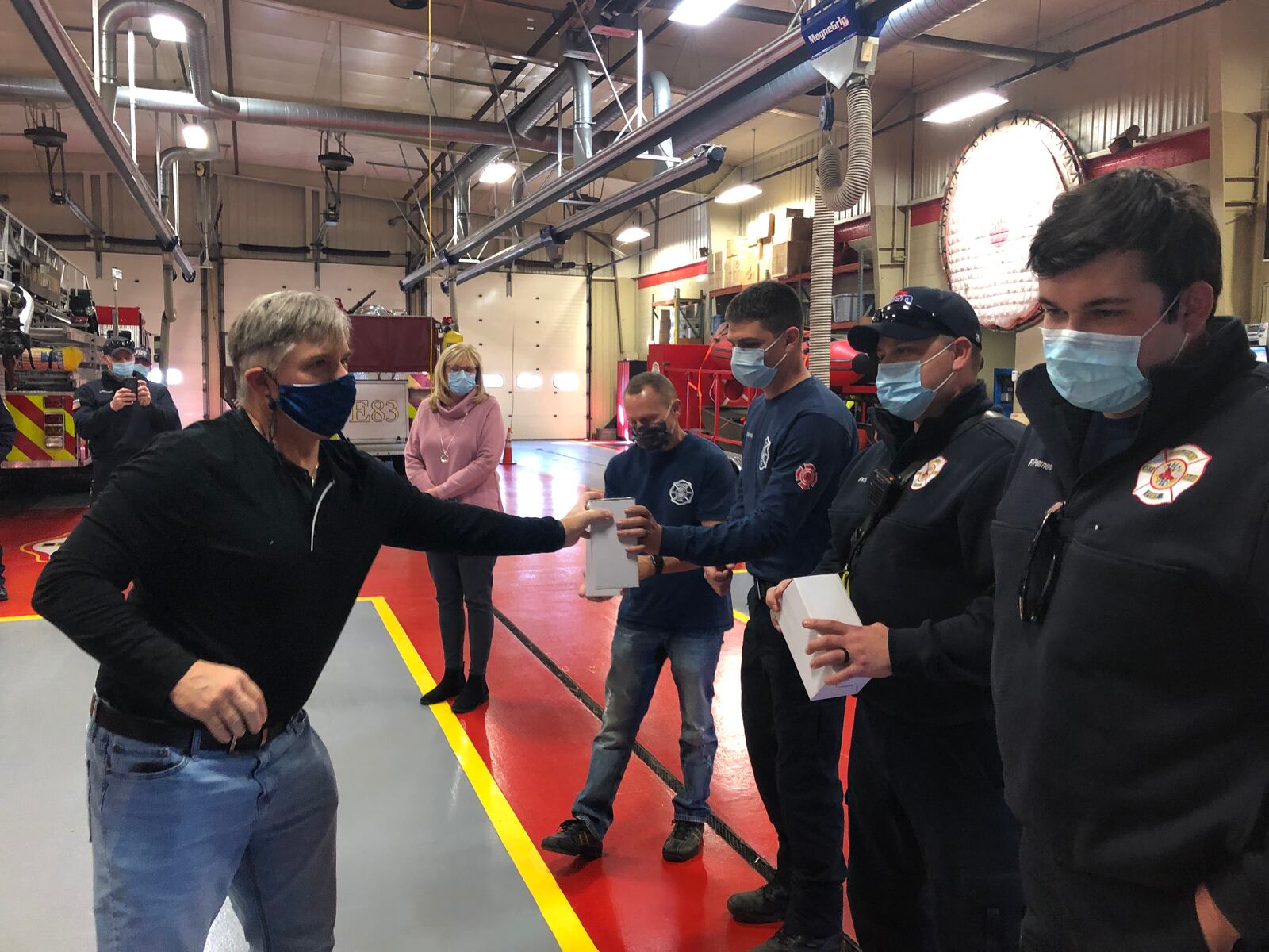 Phil Keegan, 58, presents insulated tumblers to four of the five Middletown firefighters/paramedics who saved his life. RICK McCRABB/STAFF