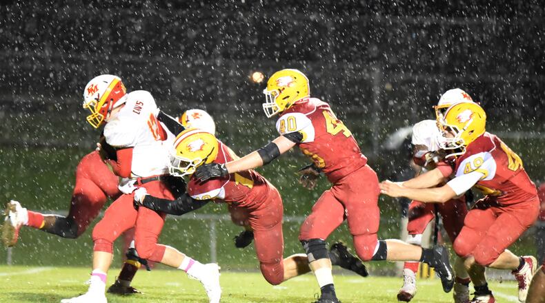 Fenwick’s Tyler Houck (19), Carter Earls (40) and Paul Bailey (49) go after Purcell Marian quarterback Zach Hoover (12) on Friday night at Krusling Field in Middletown. Fenwick won 31-14. CONTRIBUTED PHOTO BY ANGIE MOHRHAUS