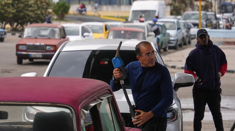 A driver refuels others wait in a long line behind to fill up at a gas station in Havana, Cuba, Tuesday, Jan. 27, 2026. (AP Photo/Ramon Espinosa)